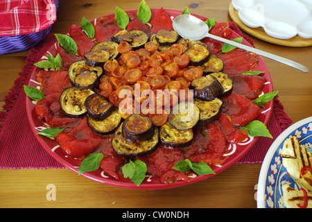 Gebratene Scheiben von Ei zu Pflanzen, Cherry-Tomaten, rote Paprika und Basilikum auf dem Teller Stockfoto