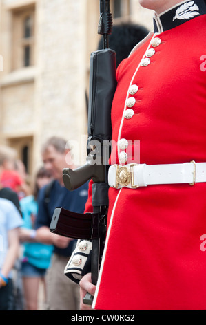 Nahaufnahme der traditionellen roten Uniform und des Gewehr der Royal Scots Guard. Tower of London UK Stockfoto