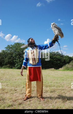 Ein Mann posiert im traditionellen Kleid Lakota (Sioux) mit eine große gehörnte Eule. Stockfoto