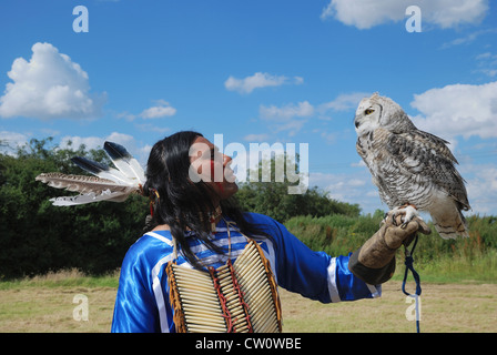 Ein Mann posiert im traditionellen Kleid Lakota (Sioux) mit eine große gehörnte Eule. Stockfoto