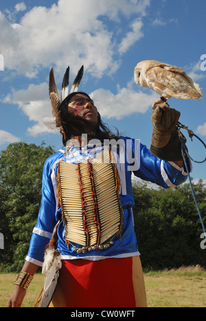 Ein Mann posiert im traditionellen Kleid Lakota (Sioux) mit einer Schleiereule. Stockfoto