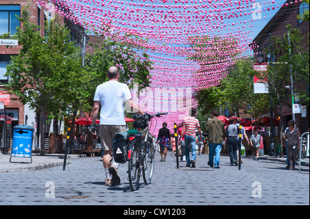 Mann zu Fuß sein Fahrrad auf ein Teil Ste Catherine Street, die geschlossen ist, Automobile in den Sommermonaten. Gay Village, Montreal. Stockfoto