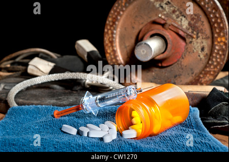 Steroid Medikation einschließlich Pillen und eine Spritze vor Trainingsgeräten. Stockfoto