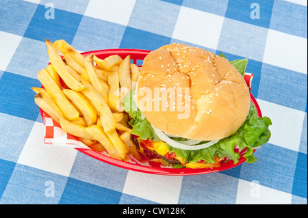 Ein Top-down-Ansicht für einen Hamburger mit Pommes frites in einem roten Korb auf einem Picknick-Tischdecke. Stockfoto