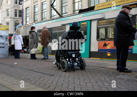 Behinderte Menschen auf eine Mobilität Scooter und andere Passagiere warten an Bord des U-Straßenbahn im Stadtzentrum von Manchester GROSSBRITANNIEN. foto DON TONGE zu Stockfoto