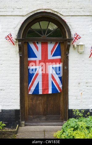 Union Jack-Flagge und Girlanden hängen an Eingangstür des historischen Gebäudes im Dorf von Brampton Bryan Herefordshire England UK Stockfoto