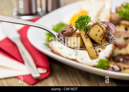 Gabel mit gebratenen Kartoffeln und Teil im Hintergrund Stockfoto