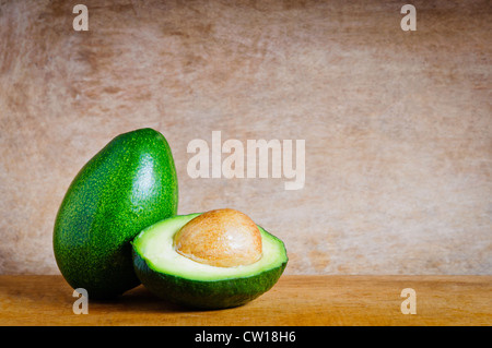Reife in Scheiben geschnittenen Avocados mit Text kopieren Speicherplatz auf einem hölzernen Hintergrund Stockfoto