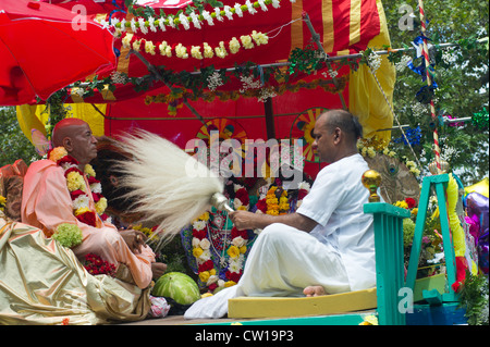 Ein Hare-Krishna-Practioner fans eine Statue von Lord Jaqannatha (Ratha Yatra) Stockfoto