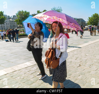 Paris, Frankreich, chinesische Touristen mit Sonnenschirmen, Ile de la Cité, Hitzewelle und Straße, sonniger Tag Stockfoto