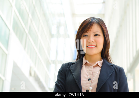 Schöne asiatische Offizier zu Fuß durch moderne Gebäude Stockfoto