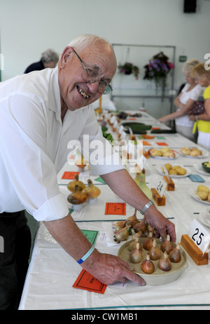 Bill Wood mit einigen seiner preisgekrönten Zwiebeln bei der Patcham Horticultural Society Annual Flower Show heute Brighton UK Stockfoto