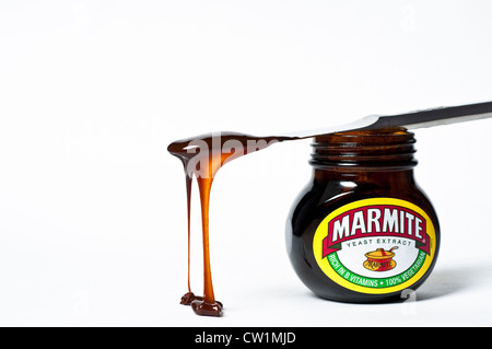 Messer mit tropfenden Marmite auf ein Glas Marmite Stockfoto