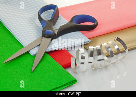 Schere, Packpapier und Band auf einem Tisch Stockfoto