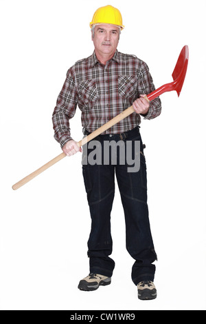 Grauhaarige Mann mit Schaufel Stockfoto