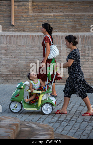 Usbekisch-Frau mit Kind im Kinderwagen, Chiwa, Usbekistan Stockfoto