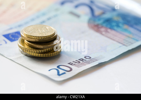 Euro-Münzen und Noten auf einem weißen Hintergrund. Stockfoto