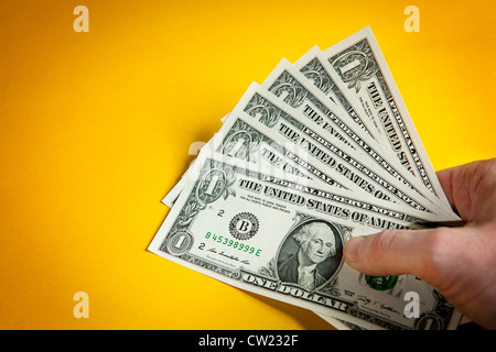 Amerikanisches Geld in der Hand auf gelbem Hintergrund Stockfoto