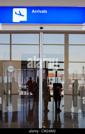 Detail der Flughafen-Ankunftshalle mit Silhouetten von unkenntlich Menschen reflektiert Ausgangstür. Stockfoto