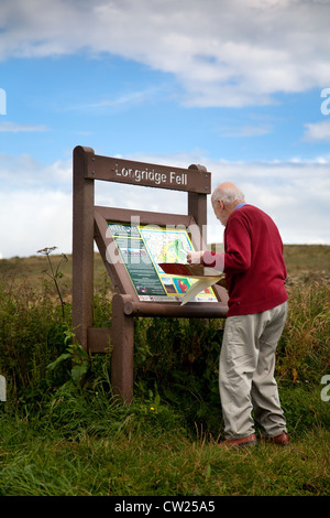 Älterer Rentner, Senior an der Informationsstelle und Karten in Longridge Fell, Wanderrouten, Trog of Bowland, Chipping, Preston, VEREINIGTES KÖNIGREICH Stockfoto