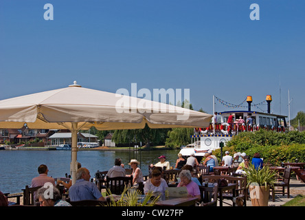 Alfresco Esszimmer neben der Fluss Bure, am Horning auf den Norfolk Broads, zusammen mit der Mississippi-Tretboot, Norfolk Stockfoto