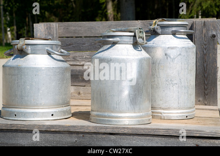 Drei verschiedene Größen Milchkannen auf Gerüst Stockfoto