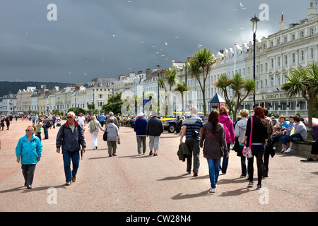 Menschen an der Promenade, an einem wechselhaften Sommertag, North Shore, Llandudno, Conwy County Borough, Wales UK. Stockfoto