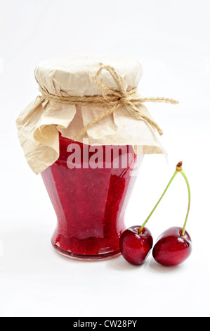 Glas hausgemachter Kirsch Marmelade und paar Kirschen Stockfoto