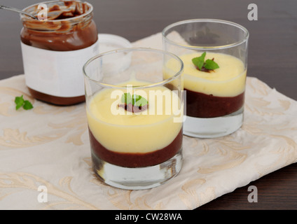 Schokolade und Vanille Creme, jar serviert in Gläsern, Choco verbreiten im Hintergrund Stockfoto