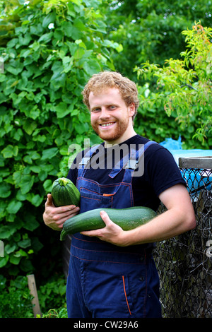 Ein junger Gärtner ernten im Garten. Stockfoto