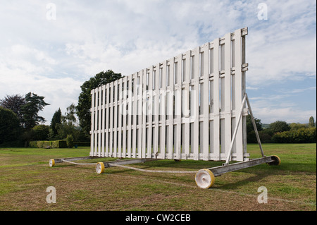 Weiß lackiertes Holz Dorf Cricket Sichtschutz auf Rollen Räder Rad gut genutzt Stockfoto