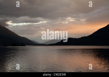 Bereich der Glen Coe, Schottland. Blick auf den Sonnenuntergang von Loch Leven, Blick nach Westen in Richtung Ballachulish Silhouette. Stockfoto