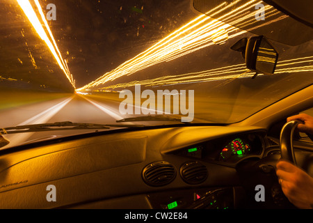 Lichtspuren durch ein Autofenster in der Nacht gesehen. Stockfoto