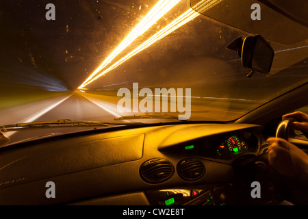 Lichtspuren durch ein Autofenster in der Nacht gesehen. Stockfoto