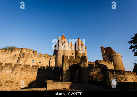 Eingang zu den Wällen und Château Comtal Türme mit Sonne auf Ihren roten Ziegeldächern in der mittelalterlichen Stadtmauer von Carcassonne. Stockfoto