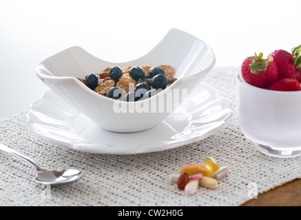 Frühstück Kleie Flocken von Blaubeeren, Erdbeeren in modernen Keramik Schüssel Stockfoto