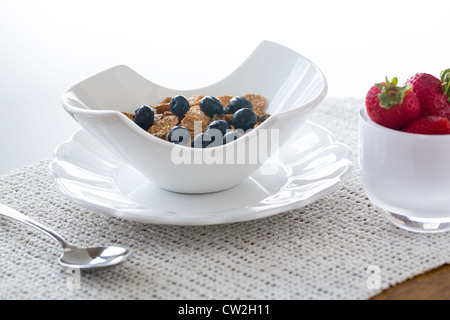 Frühstück Kleie Flocken von Blaubeeren, Erdbeeren in modernen Keramik Schüssel Stockfoto