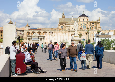 Touristen, einheimische und eine leistungsstarke Musik-Band auf der römischen Brücke in der alten Stadt von Cordoba, Spanien. Stockfoto