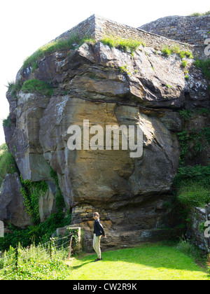 Frau, Blick auf das Meer unter spektakulären Sandstein in Ravenscar North Yorkshire Stockfoto