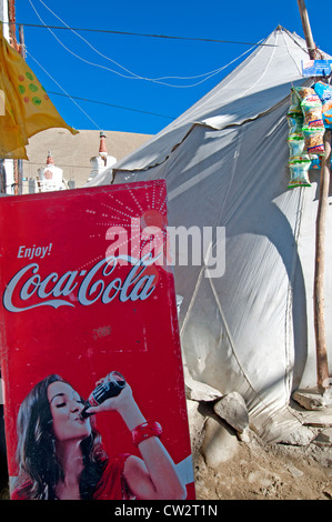 Coca-Cola Schild mit einer jungen Frau trinken eine Flasche Cola außerhalb ein Zelt Store in Korzok, Ladakh, Indien Stockfoto