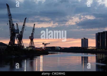 Sonnenuntergang über die Krane bei BAE Systems Werft neben dem Fluss Clyde in Govan, Glasgow, Schottland, Großbritannien Stockfoto