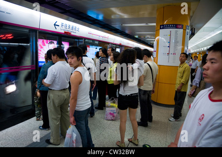 Linie 5-Plattform & chinesische Pendler / Pendler Passagiere an Bord Zug auf Beijing u-Bahn warten. Peking, China Stockfoto