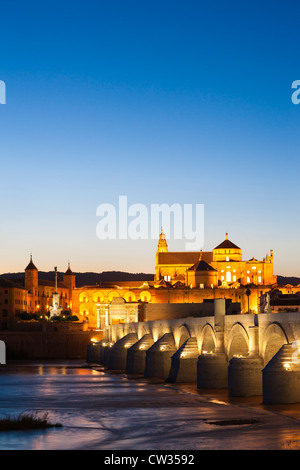 Córdoba, Spanien. Große, große Moschee, Mezquita und Kathedrale mit römischen Brücke am Fluss Guadalquivir in der Abenddämmerung.  Andalusien Andalusien Stockfoto