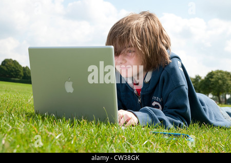 männliche junge mit Laptop-Computer im Stadtpark Stockfoto