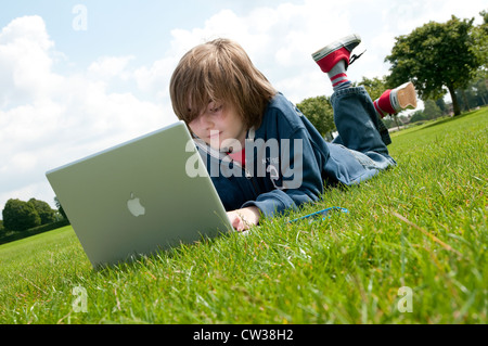 männliche junge mit Laptop-Computer im Stadtpark Stockfoto