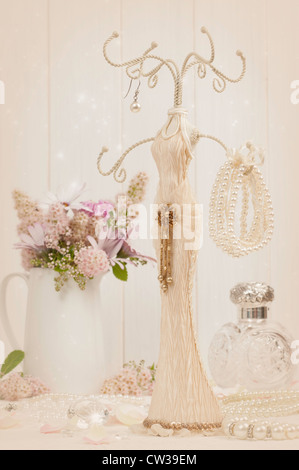 Schmuck Halter mit Armband und Perlenkette mit antiken Duft Flasche im Hintergrund Stockfoto
