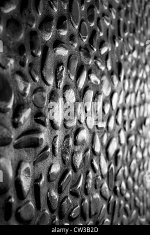 Innenwand aus glänzend schwarze Kieselsteine in Beton gegossen. Blick von bei niedrigen Winkel nach links. Wählen Sie konzentrieren. Schwarz-weiß Foto. Stockfoto