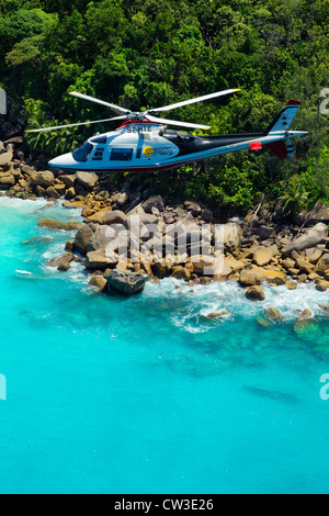 Agusta 109C Hubschrauber fliegen über der Küste Praslin.Seychelles Stockfoto