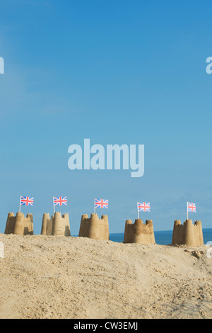 Union Jack-Flaggen in Sandburgen auf einer Sanddüne. Brunnen neben das Meer. Norfolk, England Stockfoto