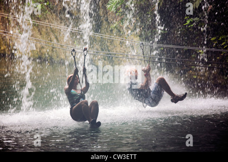 zwei Personen zip Futter durch einen Wasserfall an Xplor, ein Naturerlebnis-Park befindet sich an der Riviera Maya, Stockfoto